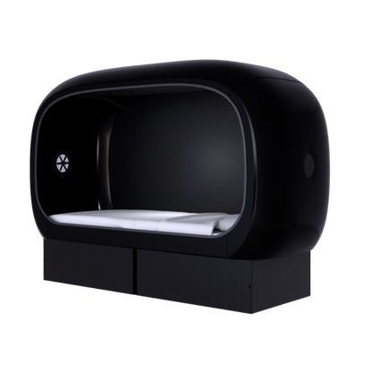 Side view of a black oval-shaped NapBox Business Pod — a modern sleeping pod with a spacious twin XL bed, pillow, and mattress inside.